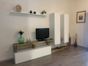 sala de estar con TV en una pared blanca en La Residenza del Centro, en Padenghe sul Garda