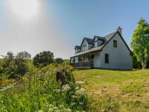 a house on a hill with a grass field at Holiday Home Ceilidhtail Cottage by Interhome in Drumnadrochit