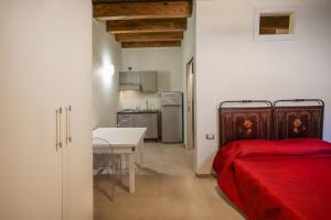 a room with a bed and a table and a kitchen at Don Bartolomeo Bellomo studio in Gratteri