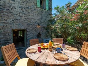drewniany stół z jedzeniem i napojami na patio w obiekcie Holiday Home Maison Penta by Interhome w mieście Penta-di-Casinca