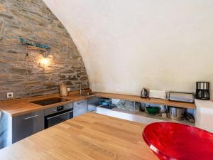a kitchen with a counter and a red chair at Holiday Home Penta by Interhome in Penta-di-Casinca