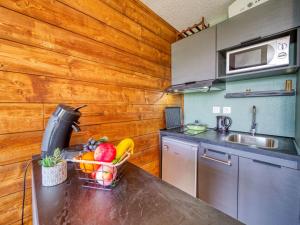 a kitchen with a table with a basket of fruit on it at Apartment Pegase Phenix-72 by Interhome in Le Corbier