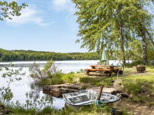 un bateau assis sur la rive d'un lac dans l'établissement Holiday Home Erikstorp Villan by Interhome, à Olofström