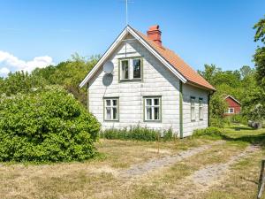 a small white house with a red roof at Holiday Home Ilingetorp - SND032 by Interhome in Torsås