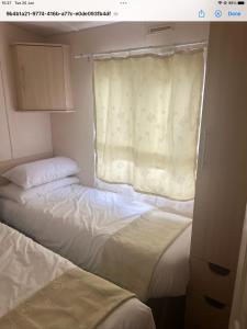 two beds in a small room with a window at Decker’s in Leven-Fife