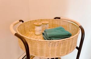 una cesta de mimbre con toallas y tazas en una silla en Little Bird Inn, en Margaretsville