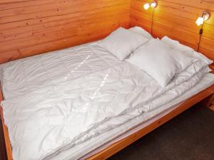 a large white bed with two pillows on it at Holiday Home Lomasyväri 810 by Interhome in Nilsiä