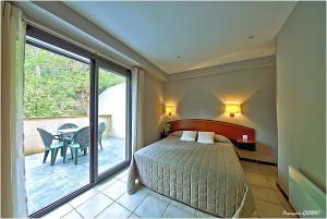 um quarto com uma cama e uma varanda com uma mesa em Auberge des Deux Sorru em Bains de Guagno