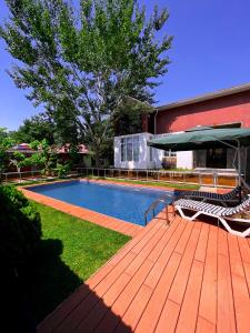 a swimming pool on a wooden deck next to a building at Qafqaz Fountain Villa in Gabala