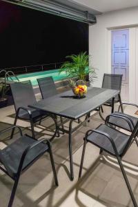 a black table and chairs with a bowl of fruit on it at Holiday Home Emili & Elias by Interhome in Karlobag