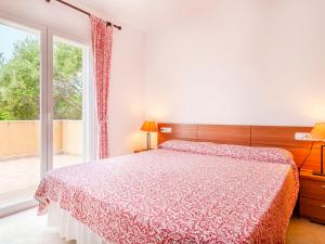 1 dormitorio con cama y ventana grande en Holiday Home Sa Coma by Interhome, en Sa Coma