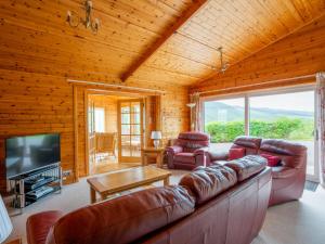 sala de estar con sofá grande y TV en Holiday Home Achmony Number 7 by Interhome, en Drumnadrochit