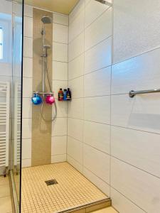 La salle de bains est pourvue d'une douche avec une porte en verre. dans l'établissement Ferienwohnung Waldblick, à Kaufungen