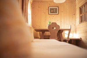 a bedroom with a table and a chair in a room at Kofler zw den Wänden Apt Himmelschlüssel in Campo Tures