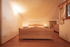 a bedroom with a wooden bed in a room at Kofler zw den Wänden Apt Himmelschlüssel in Campo Tures