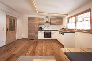 una cucina con elettrodomestici bianchi e pavimenti in legno di Kofler zw den Wänden Apt Edelweiss a Campo Tures
