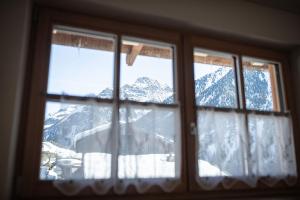 a window with a view of a snow covered mountain at Kofler zw den Wänden Apt Edelweiss in Campo Tures