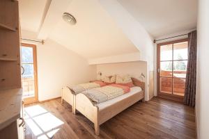 a bedroom with a bed and a large window at Kofler zw den Wänden Apt Edelweiss in Campo Tures