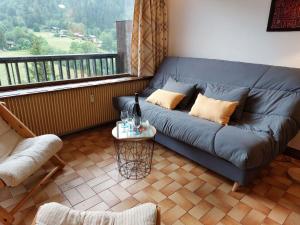 a blue couch in a living room with a window at Studio Le Bionnassay by Interhome in Les Contamines-Montjoie