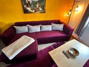 sala de estar con sofá púrpura y mesa en Apartment Frushi by Interhome, en Großschönau