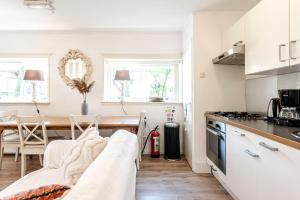 a kitchen and dining room with a couch and a table at Küstenwind in Zandvoort +9 photos