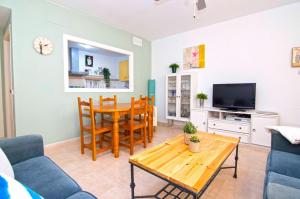 ein Wohnzimmer mit einem Tisch und einem Esszimmer in der Unterkunft Bolsa Wave Suite - Apartamentos Living Sur in Sanlúcar de Barrameda