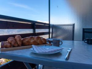 een tafel met een dienblad met brood en een kopje koffie bij Apartment Les Diablerets by Interhome in Veysonnaz