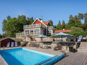 une maison avec une piscine en face d'une maison dans l'établissement Holiday Home Skarpsätter Sportgård by Interhome, à Strängnäs