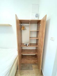 a wooden book shelf in a room with a bed at Bat Galim BEACH apartment in Haifa