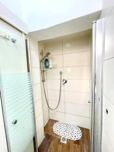 y baño con ducha y asiento de ducha. en Bat Galim BEACH apartment en Haifa