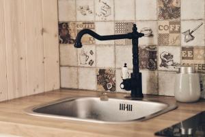 a kitchen sink with a faucet on a counter at Holiday Siesta Pensjonat, Domki in Rewal