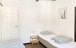 two beds in a room with white walls at Cozy Apartment In Visby With Wifi in Visby