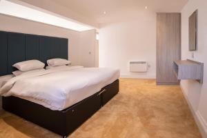 a bedroom with a large bed with a black headboard at The Castle Collection - 5 Union Court in Liverpool
