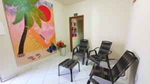 a waiting room with chairs and a painting on the wall at Pousada Beth Shalom in Conceição da Barra