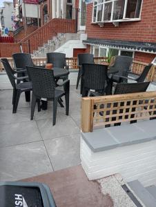 eine Gruppe von Stühlen und Tischen auf einer Terrasse in der Unterkunft The Georgian Hollies Hotel in Blackpool