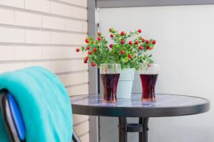two glasses on a table with a potted plant at Turzycowa Apartment in Gdansk by Renters in Gdańsk