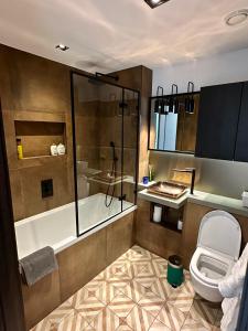 La salle de bains est pourvue d'une baignoire, de toilettes et d'une douche. dans l'établissement Luxury Central Flat with Stunning Views and Pool, à Londres