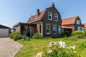 uma casa com um quintal com flores em Vakantiehuis Oostburgsestraat 44, Zuidzande em Zuidzande