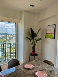a dining room table with a potted plant and a window at Luxury Central Flat with Stunning Views and Pool in London