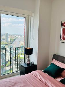 sypialnia z łóżkiem i dużym oknem w obiekcie Luxury Central Flat with Stunning Views and Pool w Londynie
