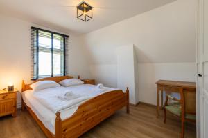 ein Schlafzimmer mit einem Bett, einem Schreibtisch und einem Stuhl in der Unterkunft Welcome in - Vakantiehuis Oostburgsestraat 44, Zuidzande in Zuidzande