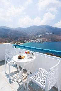 uma mesa branca e cadeiras numa varanda com vista em Aegialis Hotel & Spa em Aegiali
