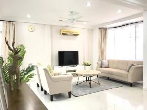 a living room with a couch and a tv at Family 4BR Landed House @ SPICE ARENA in Bayan Lepas