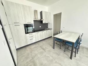 a kitchen with a wooden table and a dining room at LUX apartments in Follonica