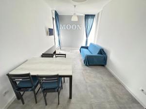Habitación con mesa, sillas y sofá azul. en LUX apartments en Follonica
