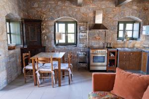 a kitchen and dining room with a table and chairs at Stone Oasis in Psíon