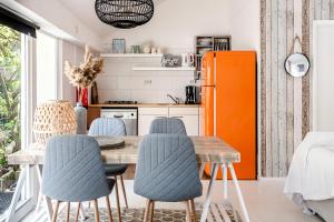 a kitchen with a table and chairs and an orange refrigerator at Hippie Beach in Zandvoort