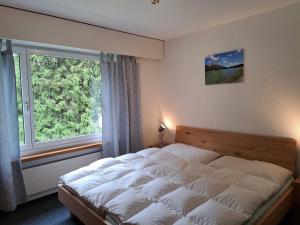una camera da letto con un letto e una grande finestra di Seegarten A (361 Ku) a Lenzerheide