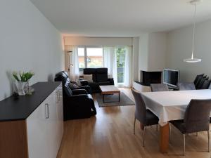 eine Küche und ein Wohnzimmer mit einem Tisch und Stühlen in der Unterkunft Seegarten A (361 Ku) in Lenzerheide
