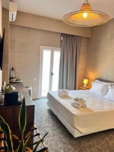 a bedroom with a large white bed and a window at Aegialis Hotel & Spa in Aegiali